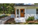 Charming front entrance with a wooden door, white brick steps, and a well-maintained yard at 207 N Aiken St, Fuquay Varina, NC 27526