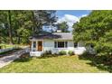Beautiful white brick home with a well-manicured lawn and mature trees at 207 N Aiken St, Fuquay Varina, NC 27526