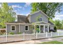 Charming two-story home with gray siding, white trim, and a welcoming front porch and a nice white picket fence at 219 Northwood Cir, Durham, NC 27701