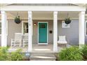 Inviting front porch with rocking chairs and a teal front door, enhanced by hanging flower baskets at 219 Northwood Cir, Durham, NC 27701