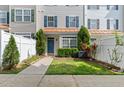 Attractive townhouse featuring a manicured lawn, tidy garden bed and blue front door at 2210 Raven Rd # 105, Raleigh, NC 27614