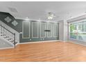 Open-concept living room featuring wood floors, fan, and stylish wall molding at 2210 Raven Rd # 105, Raleigh, NC 27614
