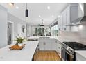 Open-concept kitchen featuring white cabinets, quartz countertops, stainless steel appliances, and island at 2325 Sheffield Rd # 102, Raleigh, NC 27610