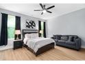 Relaxing bedroom showcasing a comfortable bed, a cozy couch, modern fan, and ample natural light at 2325 Sheffield Rd # 102, Raleigh, NC 27610