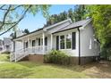 Well-kept home featuring a covered front porch and mature greenery around the property at 2402 Cynthia Dr, Durham, NC 27704