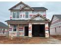 Two-story home under construction featuring an attached two-car garage and visible framing at 251 Bluejay St, Clayton, NC 27520