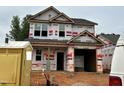 Under-construction two-story home featuring a two-car garage and framed window openings at 251 Bluejay St, Clayton, NC 27520
