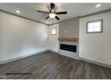Cozy living room with hardwood floors, a ceiling fan, and a modern electric fireplace with a wood mantle at 256 Bluejay St, Clayton, NC 27520