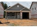 New construction exterior featuring gray siding, an attached garage and well-manicured lawn on a sunny day at 257 Bluejay St, Clayton, NC 27520