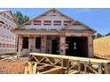 Image of a new construction home in the framing stage showcasing the exterior with a garage and Westan Homes branded house wrap at 257 Bluejay St, Clayton, NC 27520