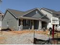 New single-story home with gray siding and a covered front porch in a developing neighborhood at 257 Bluejay St, Clayton, NC 27520
