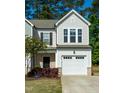 Beautiful townhome with a one-car garage, black shutters and a lovely green lawn at 261 White Oak Ridge Dr, Garner, NC 27529