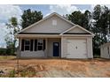 Charming single story home featuring gray siding, a blue front door, an attached garage, and well manicured landscaping at 31 Goldenrod Loop, Clayton, NC 27520