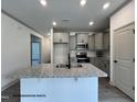 Modern kitchen with granite countertops, stainless steel appliances, recessed lighting, and grey cabinets at 31 Goldenrod Loop, Clayton, NC 27520