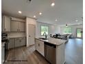 Open-concept kitchen flowing into the living room with granite counters and stainless appliances at 31 Goldenrod Loop, Clayton, NC 27520