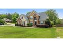 Stately two-story home featuring brick and siding, mature landscaping, and a lush green lawn at 321 Nortwick Rd, Rolesville, NC 27571