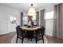 Stylish dining area with a round table, modern chandelier, and natural light from the windows at 3233 Pelican Ln, Durham, NC 27703