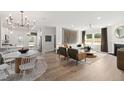 Open-concept living space featuring hardwood floors, a cozy fireplace, and an adjacent dining area at 3233 Pelican Ln, Durham, NC 27703