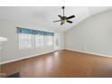 Bright living room with a vaulted ceiling, fan, laminate floors, and windows offering plenty of natural light at 3519 Streams Of Fields Dr, Raleigh, NC 27604
