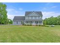 Beautiful two-story home featuring a welcoming front porch and well-manicured lawn on a sunny day at 3805 Euliss Rd, Burlington, NC 27215