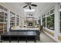 The sunroom features a stone fireplace, ceiling fans and lots of natural light at 402 Troycott Pl, Cary, NC 27519