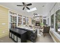 The sunroom features a stone fireplace, ceiling fans and lots of natural light at 402 Troycott Pl, Cary, NC 27519