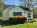 Traditional home showcasing its white siding, green shutters, and mature, flowering shrubbery at 409 Vista Springs Cir, Holly Springs, NC 27540