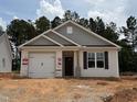 Charming single-story home featuring a classic white facade, dark shutters, and a two-car garage in a residential neighborhood at 41 Goldenrod Loop, Clayton, NC 27520