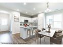 Open concept kitchen and dining area with an island, stainless steel appliances, and breakfast bar seating at 41 Goldenrod Loop, Clayton, NC 27520