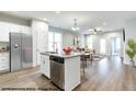 Kitchen with stainless appliances, a breakfast bar, and granite counters seamlessly open to the adjacent dining and living areas at 41 Goldenrod Loop, Clayton, NC 27520