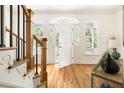 Bright foyer featuring hardwood floors, white trim, staircase, and a door leading to the outdoors at 4215 Cobscook Dr, Durham, NC 27707