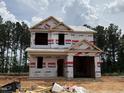Two-story home with a attached garage, covered with HomeGuard wrap, under construction at 49 Goldenrod Loop, Clayton, NC 27520