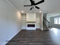 Spacious living room with a modern electric fireplace, built-in shelves, and hardwood floors at 49 Goldenrod Loop, Clayton, NC 27520