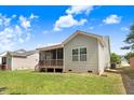 Spacious backyard featuring a covered porch, lush green lawn, and mature trees at 494 Mulberry Banks Dr, Clayton, NC 27527