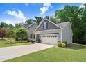 Charming single-Gathering home with a well-manicured lawn, gray shingles, and a two-car garage at 494 Mulberry Banks Dr, Clayton, NC 27527