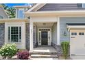 Inviting front entrance with stone accents, well-kept landscaping, and a black front door at 494 Mulberry Banks Dr, Clayton, NC 27527