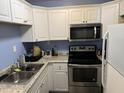 Efficient kitchen with stainless steel appliances, granite countertops, and white cabinets at 500 Umstead # 208D, Chapel Hill, NC 27516