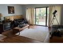 Bright living room features hardwood floors, cream rug, sliding glass doors, and a telescope at 500 Umstead # 208D, Chapel Hill, NC 27516