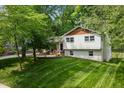 Well-manicured lawn surrounds this charming home with white siding and red brick accents at 5505 Knollwood Rd, Raleigh, NC 27609