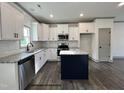 Modern kitchen with white cabinets, granite countertops, stainless steel appliances, and a center island at 57 Goldenrod Loop, Clayton, NC 27520