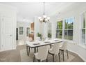 Elegant dining room with marble table, chandelier, and bright natural lighting at 6539 Clarksdale Ln, Durham, NC 27713