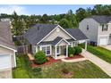 Home with a fenced yard, mature landscaping, and an attached garage at 7028 Pebble Brook Way, Rocky Mount, NC 27804