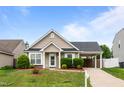 Inviting home featuring a well-maintained lawn and a covered parking at 7028 Pebble Brook Way, Rocky Mount, NC 27804