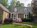 Beautiful brick home with dormer windows, white trim, and lush landscaping at 8 Greenside Ct, Durham, NC 27707