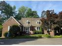 Quaint brick home featuring a cozy front porch and manicured landscaping at 8 Greenside Ct, Durham, NC 27707