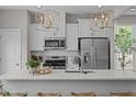 Bright kitchen with stainless steel appliances, white cabinets, quartz counters, and modern lighting at 906 Kensley Grove Ln # 68, Fuquay Varina, NC 27526