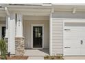 Inviting front entrance with black door, stone accents, and covered porch, leading to a well-maintained home at 908 Kensley Grove Ln # 68, Fuquay Varina, NC 27526