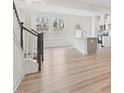Open-concept living room with wood floors, natural light, and seamless transition to the kitchen at 908 Kensley Grove Ln # 68, Fuquay Varina, NC 27526