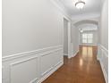 Hallway with a decorative wainscotting and wood floors leads to a living space at 10 Currituck Ln, Durham, NC 27703