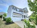 Two-story home with attached garage and welcoming porch, complemented by well-maintained landscaping at 1002 Dogwood Bloom Ln, Knightdale, NC 27545